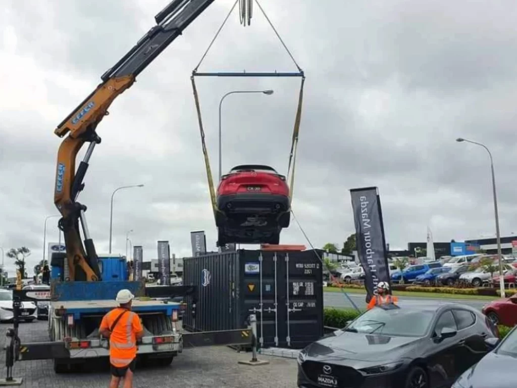 hiab hire truck lifting a car out of a shipping container
