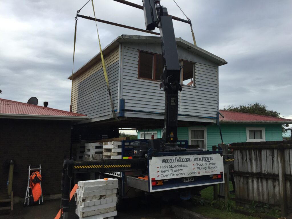 A small house being lifted with a Hiab